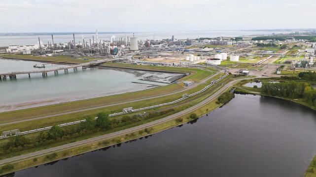 industrial pier pipeline bridge stretch across calm waters skyline distillation towers cooling chimneys defines petrochemical complex netherlands long chemical factories dow chemicals terneuzen 