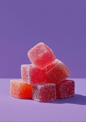 Pile of red sugar-coated fruit jellies stacked against a vibrant purple background
