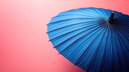 Blue umbrella against pink background;  summer protection; design element