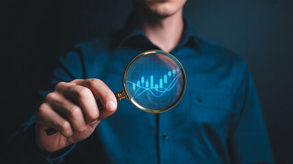 Man examining financial graph with magnifying glass in dark blue shirt with professional lighting for business analysis