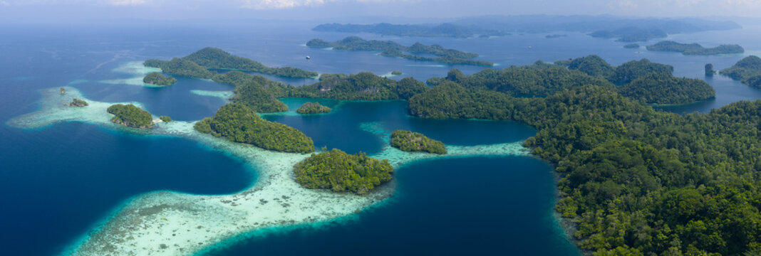 Shallow coral reefs fringe the beautiful islands of Pef, Raja Ampat, Indonesia. This region harbors spectacular marine biological diversity and is a popular destination for divers and snorkelers.