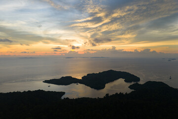A beautiful sunset silhouettes the islands of Gam and Yangeffo in Raja Ampat, Indonesia. This area is known as the heart of the Coral Triangle due to its incredible marine biodiversity.