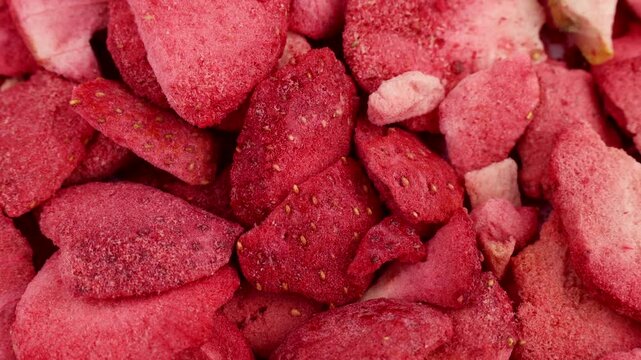 Red freeze dried strawberry slices texture circle rotation close up