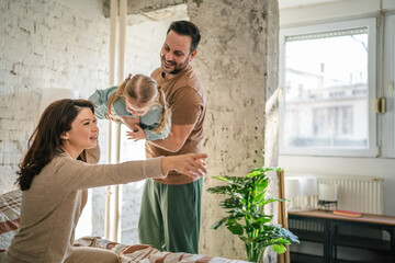 Obraz premium Happy family playing together in bedroom at home