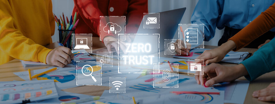 A vibrant workspace depicts teamwork around digital charts, emphasizing the zero trust security approach. The scene showcases collaboration and innovation in a modern office environment. Trope - Powered by Adobe