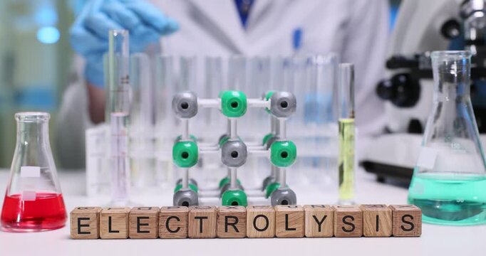 Cubes form term Electrolysis indicating conducted process. Laboratory worker examines test tubes filled with liquids observing differences in color