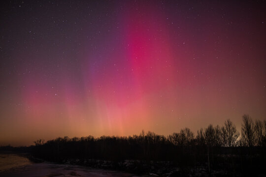 Aurora borealis in the night in Poland. Night sky with stars, clouds and Aurora Borealis.