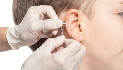 Closeup of a clinicians hand holding a l speculum inspecting a childs l cavity against a clean white backdrop highlighting pediatric ENT examination.