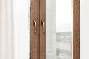 Brown plastic window frame with fittings close-up. Upvc windows and doors accessories and hardware. Concept of construction, renovation and finishing works