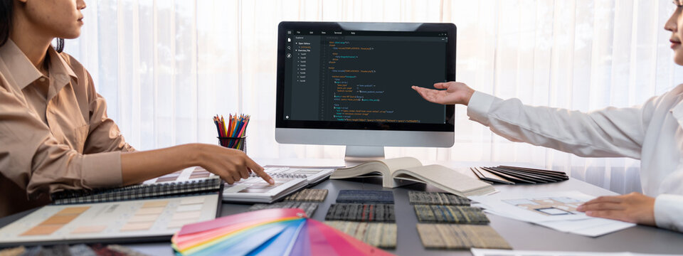 Group of interior architect designer team at table choosing various mood board samples with architecture software on laptop screen. Modern renovation and interior material selection concept. Insight