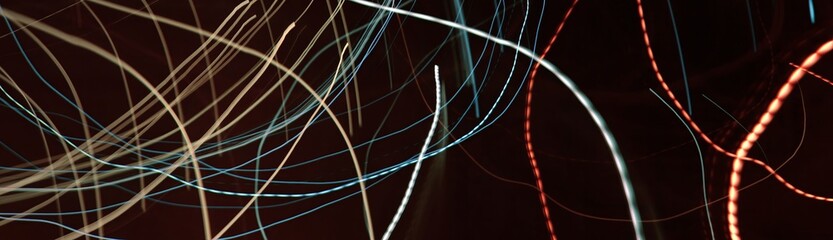 Abstract neon light trails. Long exposure. Dark motion blur background with copy space.