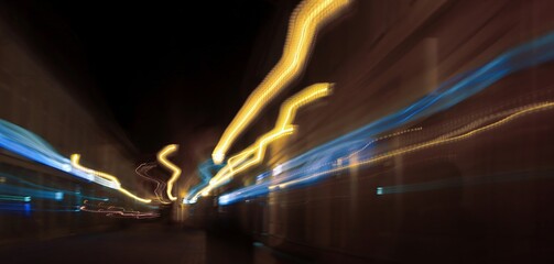 Linear composition. Аbstract long-exposure photograph depicting colorful neon light trails against a dark background.