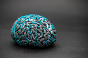 Human brain entwined with blue thread. Concept of neurology, nervous system or human mind.
