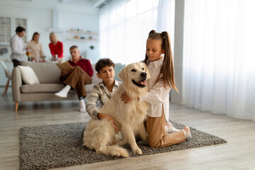 Cute children with golden retriever dog sitting on floor at home, their parents and grandparents on...