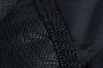 An extreme close-up view showing the heavy-duty stitching and reinforced binding on the edge of the...