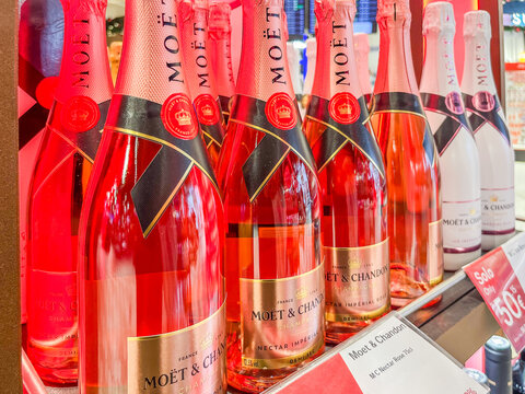 Malaga, Spain - December 21, 2025: Moet and Chandon Nectar Imperial Rose bottles displayed on a shelf with vibrant colors and promotional signage in a retail environment