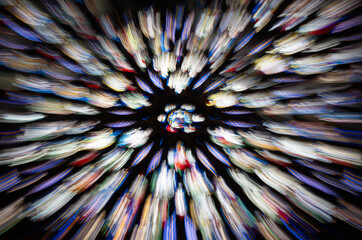 Abstract zoom burst of a colorful Gothic rose window in the Sainte Chapelle of Paris, radiant motion blur creates a kaleidoscopic effect of vibrant stained glass colors