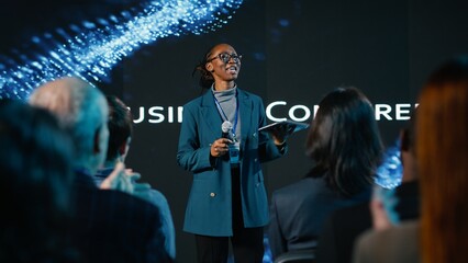 African american young adult hosting a panel discussion during international business event with...