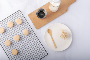 A bag of homemade cookies, a bottle of milk, and a cup of coffee.