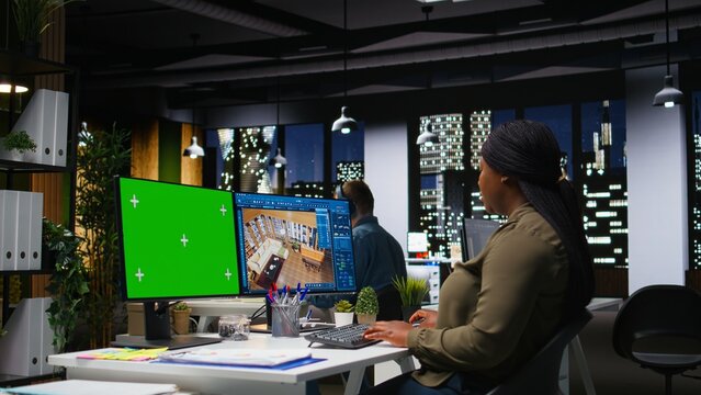 Isolated mockup and CAD software used by black female graphic designer to create a modern layout, 3D modeling program and chroma key on dual monitors. Architectural design assets. Camera A.