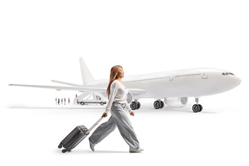 Full length profile shot of a young woman near an airplane walking with a suitcase