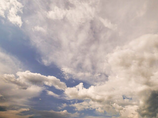 Obraz premium The sky is cloudy and the sun is shining through the clouds. The sky is blue and the clouds are white