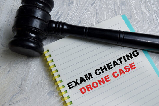 Concept of exam cheating drone case write on book isolated on Wooden Table. Representing academic integrity, education law, and legal decision