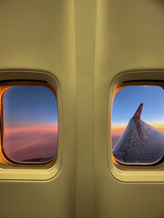 Naklejka premium View from airplane window with wing and sunset sky