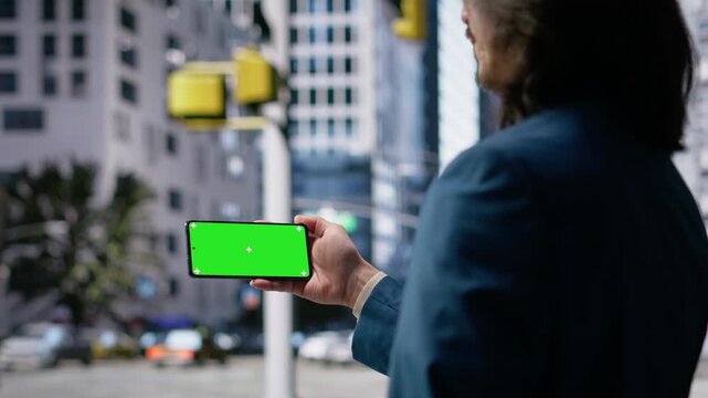 Horizontal isolated screen on smartphone near city crowd of different ages crossing together reflects multicultural motion, daily commute activity and flow of modern street life. Camera B.
