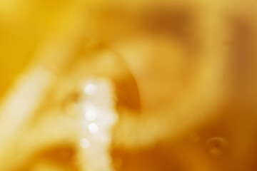Blurry view of golden oil splash as background