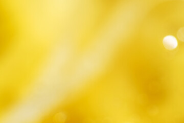 Blurry view of golden oil splash as background