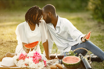 African american couple with watermelon on a meadow