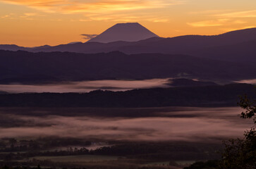 Fototapeta premium 黒松内町の山より望む朝日に染まる雲海と山並み 朝焼けの羊蹄山と雲海