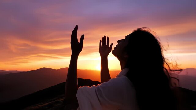 Woman praying looking up with hands open to sky silhouette beautiful sunset
