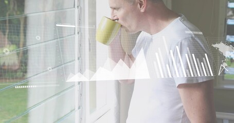 Sipping senior man in white T-shirt at home by louvered window, holding yellow mug, viewing charts