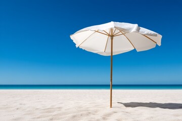 Solitary Beach Umbrella Casting Shadow on White Sand Under Clear Blue Sky