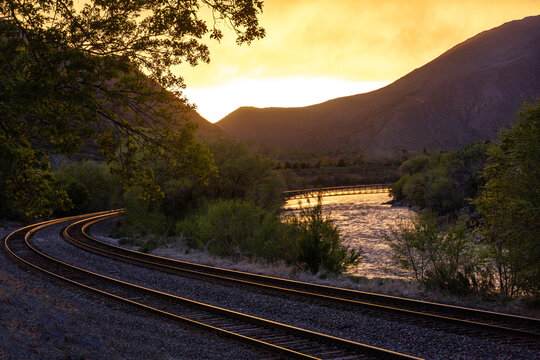 sunset near a river and train tracks