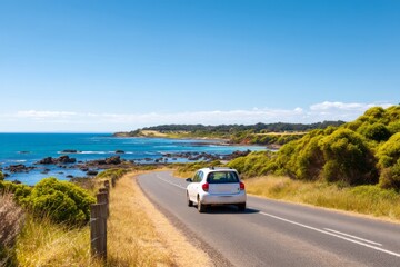Fototapeta premium Scenic Summer Road with a Small Car Passing Through Beautiful Landscape
