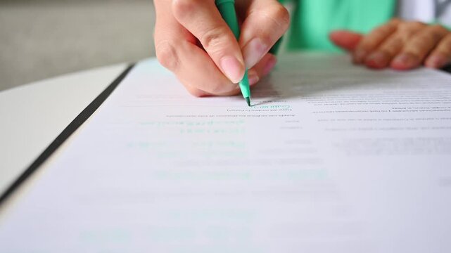 Close-up of businesswoman hands signing a contract on a desk, video 4k real time