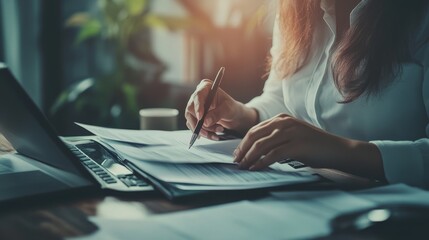 Focused woman writing notes on paper at desk with pen creative work process and thoughtful expression.