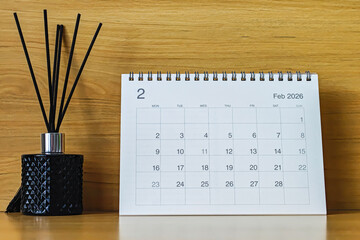 Office desk calendar showing February 2026 with copy space on wooden background, ideal for business planning, scheduling, and time management concepts.