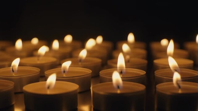 Rows of Tealight Candles Glowing on Dark Background Still Life