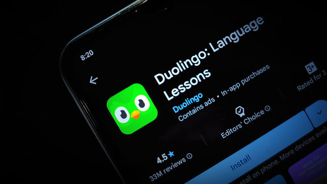 A smartphone screen displaying the Duolingo app store page in a dark environment