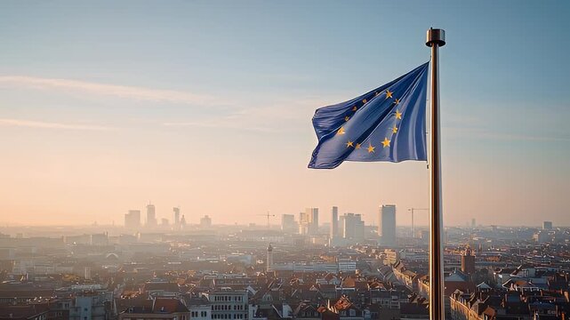 The European Union flag stands above a city at sunset