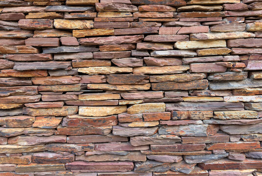 Natural stacked stone wall texture background in warm earthy tones, a rustic background