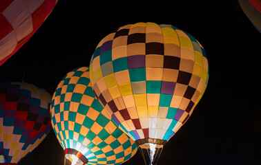 colorful hot air balloons glowing against dark night sky