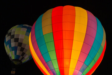 colorful hot air balloons glowing against dark night sky