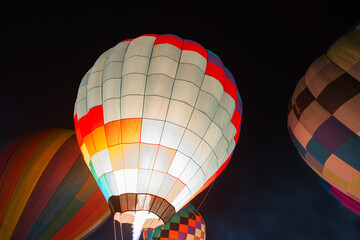 colorful hot air balloons glowing against dark night sky