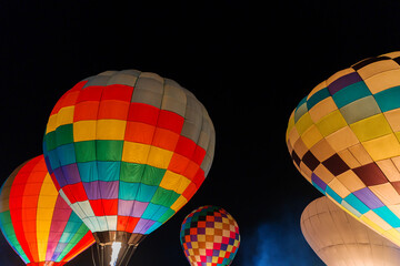 colorful hot air balloons glowing against dark night sky