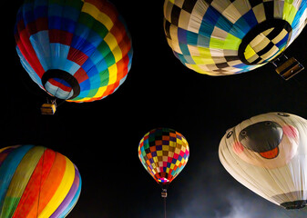 colorful hot air balloons glowing against dark night sky